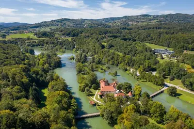 an aerial view of a house on a river at Hotel Grad Otočec - Relais Chateaux in Otočec