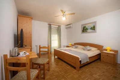a bedroom with a bed and a table and a desk at Rooms & Apartments Pr Matjon in Bled