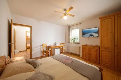 a bedroom with a large bed with a ceiling fan at Rooms & Apartments Pr Matjon in Bled