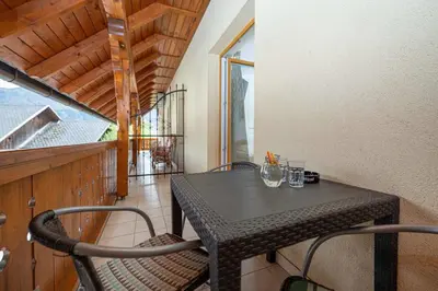 a black table and chairs on a balcony at Rooms & Apartments Pr Matjon in Bled