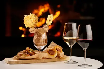 two glasses of wine and some food on a table at Bohinj Eco Hotel in Bohinj
