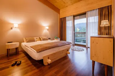 a bedroom with a bed and a large window at Bohinj Eco Hotel in Bohinj