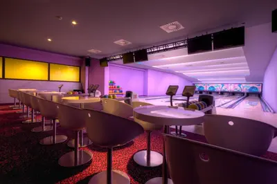 a bowling alley with tables and chairs and a bowling alley at Bohinj Eco Hotel in Bohinj