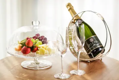 a bowl of fruit and a bottle of wine on a table at Bohinj Eco Hotel in Bohinj