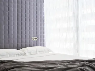 a bedroom with a bed with a large headboard and a window at Vander Urbani Resort - a Member of Design Hotels in Ljubljana