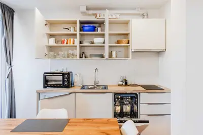a kitchen with white cabinets and a sink at Apartments Skok with rafting and free parking in Bovec