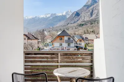 a balcony with a table and chairs and mountains at Apartments Skok with rafting and free parking in Bovec