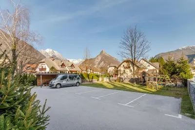 a car parked in a parking lot with mountains in the background at Apartments Skok with rafting and free parking in Bovec