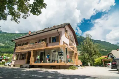 a building with a store in the middle of a street at Apartments Skok with rafting and free parking in Bovec