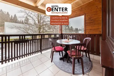 a patio with a table and chairs on a balcony at Hotel Center Bohinjsko Jezero in Bohinj
