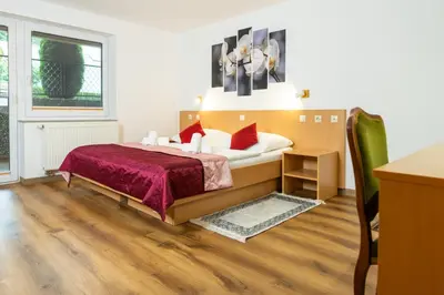 a bedroom with a bed with red pillows at Hotel Center Bohinjsko Jezero in Bohinj