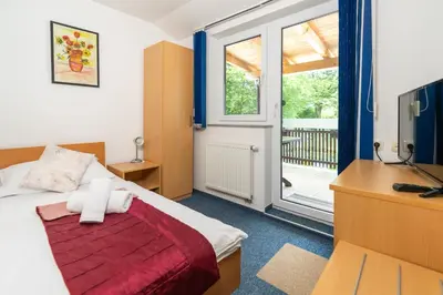 a bedroom with a bed and a desk and a window at Hotel Center Bohinjsko Jezero in Bohinj