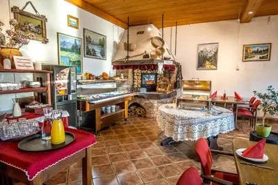 a restaurant with a fireplace and tables and chairs at Hotel Center Bohinjsko Jezero in Bohinj