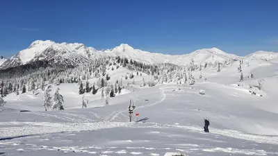 a person is standing on a snow covered mountain at Chalet Kanja Velika Planina in Stahovica