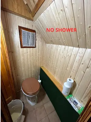 a bathroom with a toilet and a no shower sign at Chalet Kanja Velika Planina in Stahovica