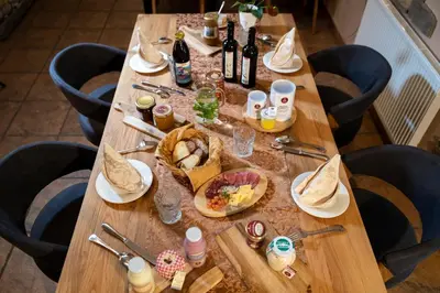 a long wooden table with food and bottles of wine at Art Hotel Kristal in Bohinj