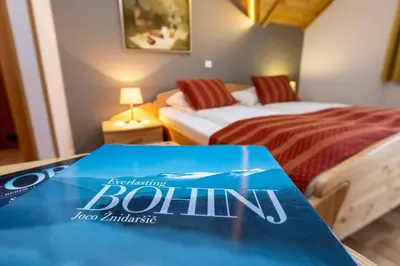 a hotel room with two beds and a book on a table at Art Hotel Kristal in Bohinj