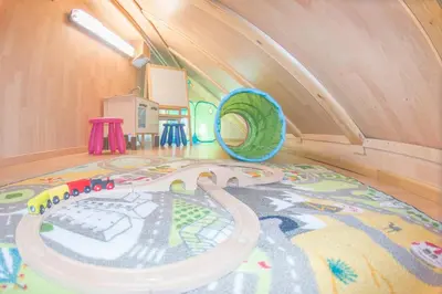 a childs play room with a toy track on the floor at Berghi Hotel and Apartments in Kranjska Gora