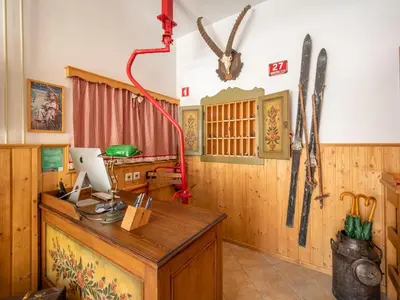 a room with a desk and skis on the wall at Berghi Hotel and Apartments in Kranjska Gora