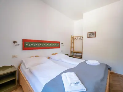 two twin beds in a room with white walls at Berghi Hotel and Apartments in Kranjska Gora