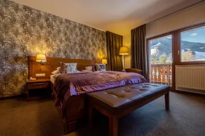 a hotel room with a bed and a large window at Hotel Lipa in Kranjska Gora