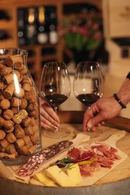 a table with two glasses of wine and food at Hotel Lipa in Kranjska Gora