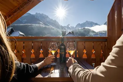 two people sitting at a table with glasses of wine at Hotel Lipa in Kranjska Gora