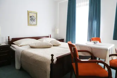 a bedroom with a bed with a table and a chair at Vila Romana in Kranjska Gora