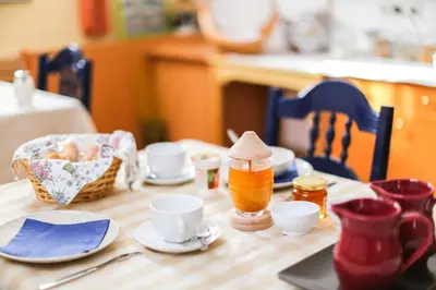 a wooden table topped with cups and a basket of food at Vila Romana in Kranjska Gora
