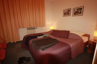 a hotel room with a bed with a red blanket at Vila Romana in Kranjska Gora