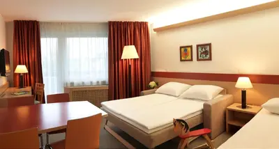 a bedroom with a bed and a desk and a table at Garni Hotel Savica - Sava Hotels & Resorts in Bled