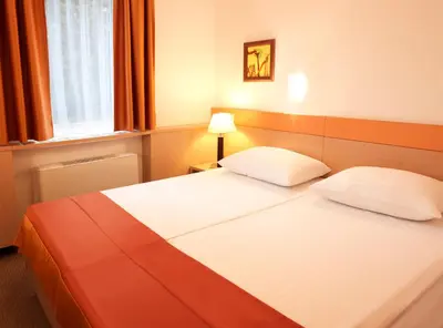 a hotel room with two beds and a window at Garni Hotel Savica - Sava Hotels & Resorts in Bled