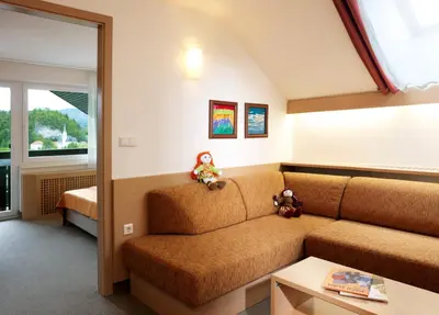 a living room with a couch and two teddy bears at Garni Hotel Savica - Sava Hotels & Resorts in Bled