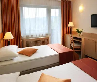 a hotel room with two beds and a window at Garni Hotel Savica - Sava Hotels & Resorts in Bled