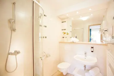 a bathroom with a toilet and a sink and a shower at Garni Hotel Savica - Sava Hotels & Resorts in Bled