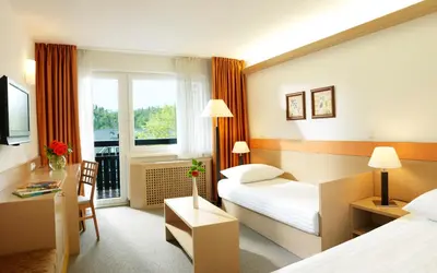 a hotel room with two beds and a window at Garni Hotel Savica - Sava Hotels & Resorts in Bled