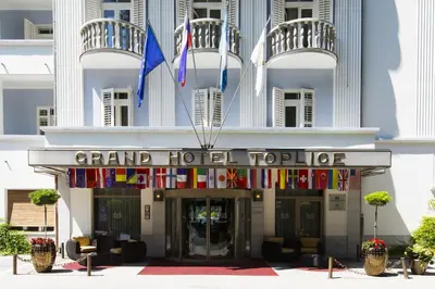 a hotel with flags on the front of it at Grand Hotel Toplice - Small Luxury Hotels of the World in Bled