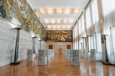 a large room with white chairs and a painting on the wall at Vila Bled in Bled