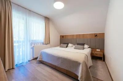 a bedroom with a bed and a large window at Penzion Livada in Kranjska Gora