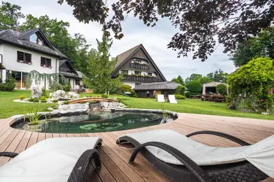 a backyard with a pond and a house at Alp Pension in Bled