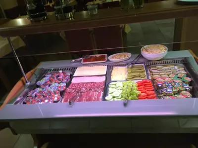 a display case filled with lots of different foods at Hotel Vila Emei in Maribor