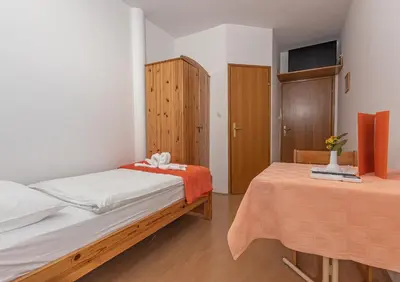 a bedroom with two beds and a wooden cabinet at Gostisce Golob in Zgornja Polskava