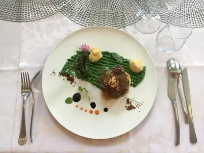 a white plate with a piece of food on a table at Hotel Leonardo in Slovenska Bistrica