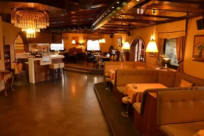 a restaurant with couches and tables and a bar at Hotel Leonardo in Slovenska Bistrica