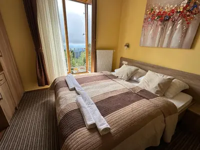 a bedroom with a bed with two towels on it at Hotel Zarja in Pohorje