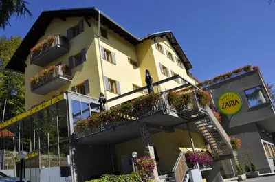 a yellow building with flower boxes and balconies at Hotel Zarja in Pohorje