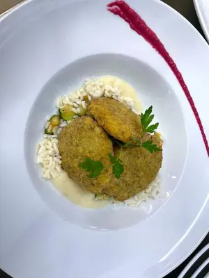 a white plate of food with rice and meatballs at Hotel Zarja in Pohorje