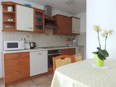 a kitchen with a table with a vase of flowers at Apartments and Rooms Tavcar in Bled