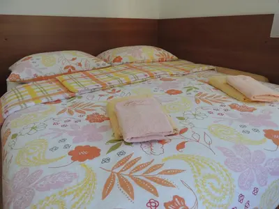 a bed with two pillows and a blanket on it at Apartments and Rooms Tavcar in Bled