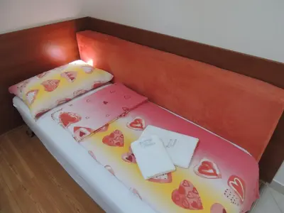 a bed in a box with hearts on it at Apartments and Rooms Tavcar in Bled